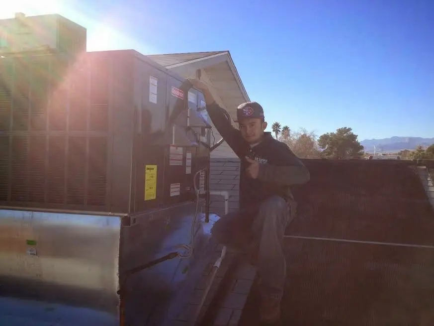 HVAC technician performing AC Tune-Up on a rooftop unit in Camp Hill